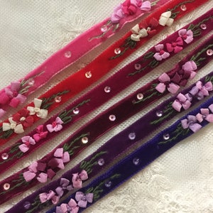 May include: Six velvet ribbons with embroidered flowers and sequins. The ribbons are in shades of pink, red, purple, and blue.
