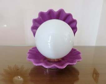 May include: A purple ceramic lamp shaped like a seashell with a white globe in the centre.