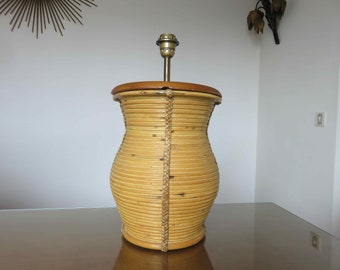 May include: A woven bamboo table lamp with a brown wooden base and a brass lampshade.