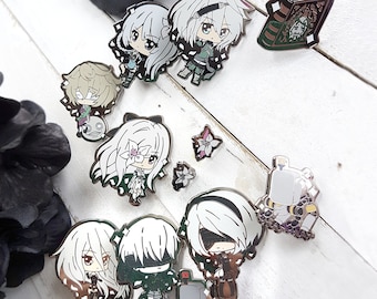 May include: A set of 10 enamel pins featuring various characters and designs. The pins are silver with black and white details. Some of the characters include a girl with long white hair, a girl with long black hair, and a robot. The pins are perfect for adding a touch of whimsy to your backpack, jacket, or bag.