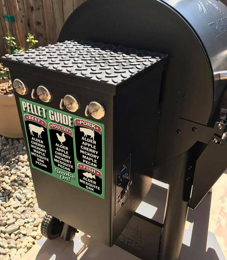 May include: A black smoker grill with a green and red sticker that says "Pellet Guide" and lists different wood types for smoking beef, poultry, pork, and fish. The sticker includes the text "Smoke On!"