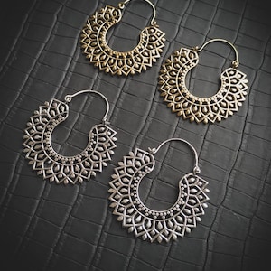 Peut inclure: Quatre paires de boucles d'oreilles créoles avec des motifs complexes et ornés. Deux paires sont en argent et deux paires sont en or.