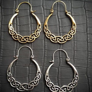 Peut inclure: Quatre boucles d'oreilles créoles avec un motif de nœud celtique. Deux sont dorées et deux sont argentées.