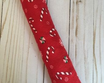 May include: Red fabric catnip toy shaped like a long pillow with a Christmas candy cane and snowflake pattern.