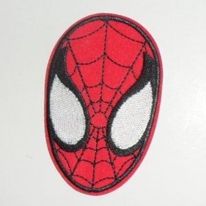 May include: A red, oval-shaped patch featuring the face of Spider-Man. The design includes white eye shapes outlined in black, and a black web pattern over a red background. The patch is likely for clothing or accessories.