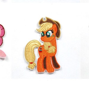 May include: Three embroidered iron-on patches featuring cartoon ponies. The first is a pink pony with a curly mane, the second is an orange pony wearing a brown cowboy hat, and the third is a pink pony with a dark blue and purple mane and tail.