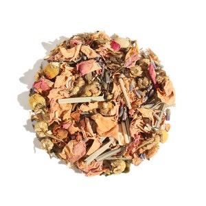 May include: A close-up of a blend of dried herbs and flowers for tea. The mix includes dried rose petals, chamomile flowers, lavender buds, and lemongrass.