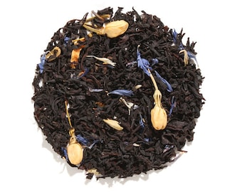 May include: A close-up of a blend of black tea leaves, blue cornflower petals, and dried jasmine flowers.