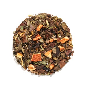 May include: A close-up of a blend of white tea leaves, dried orange peel, and other botanicals. The tea is a light brown color with orange and white accents.