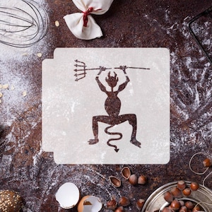 May include: A white stencil with a black silhouette of a devil holding a pitchfork. The stencil is on a brown surface with flour scattered around it.
