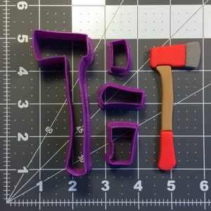 May include: A set of four purple plastic cookie cutters shaped like an axe, a handle, and two different sized squares. The axe cutter is 12.7 cm tall and the handle cutter is 10.2 cm tall.