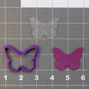 May include: Three butterfly cookie cutters, one clear plastic and two purple plastic. The clear cutter is larger than the purple cutters.