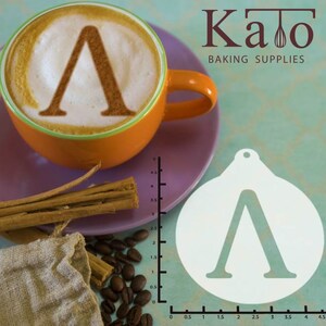 May include: White plastic stencil of the Greek letter lambda, 4.5 inches in diameter, on a light blue background. A cup of coffee with the same letter design in the foam is in the background.