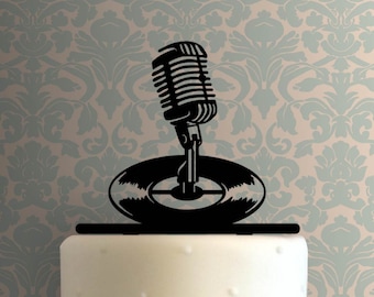 May include: Black silhouette of a vintage microphone and record on a white cake. This cake topper is perfect for a music themed party.