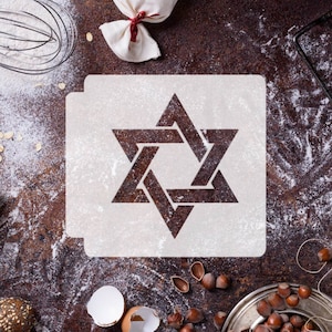 May include: A white stencil with a brown Star of David design on a brown surface with flour and other baking ingredients.