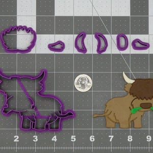 May include: A collection of purple cookie cutters in the shape of a Highland cow and its parts. The assembled cow is brown with white horns and green grass in its mouth. A quarter is included for size reference.