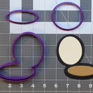 May include: Purple plastic cookie cutters in the shape of a circle, an oval, and a compact with a lid. The compact has a brown bottom and a white top.