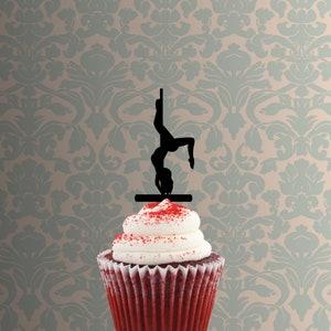 Könnte beinhalten: Eine schwarze Silhouette einer Person, die einen Pole Dance auf einem roten Samt-Cupcake aufführt.
