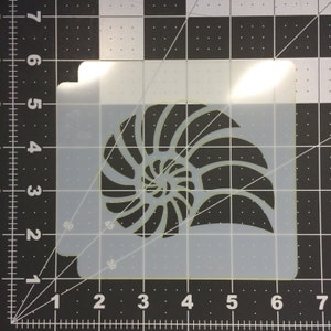 May include: A white plastic stencil of a nautilus shell. The shell is detailed with a spiral pattern.