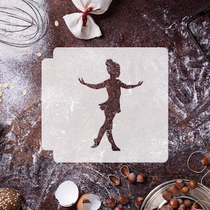Puede incluir: Una plantilla blanca con una silueta de una bailarina en pose de baile. La plantilla está sobre una superficie marrón con harina y otros ingredientes para hornear.