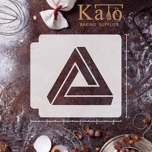 Könnte beinhalten: Weiße Kunststoffschablone mit einem schwarzen geometrischen Design eines Dreiecks mit einem Dreieck im Inneren. Die Schablone befindet sich auf einer braunen Oberfläche mit einem Lineal, das in Zoll gekennzeichnet ist.