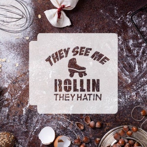 May include: White stencil with the text "They See Me Rollin' They Hatin'" and a roller skate graphic.