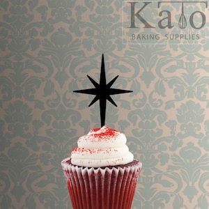 May include: A red velvet cupcake topped with white icing and red sprinkles. A black star-shaped cupcake topper is inserted into the icing.