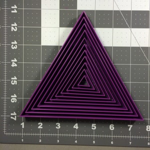 May include: A set of ten purple triangle-shaped cookie cutters, nested inside each other, with the largest cutter measuring approximately 20 cm across.