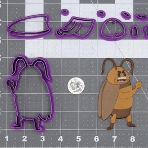 May include: A collection of purple plastic cookie cutters in various shapes, including a cartoon cockroach and its parts. A finished cockroach cookie is also present. A US quarter is included for size reference. The cutters are on a gray grid surface.