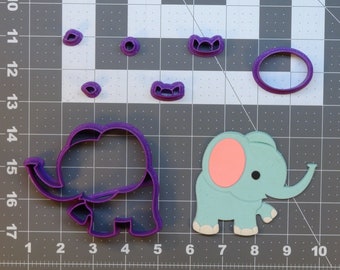 May include: A collection of purple plastic elephant-shaped cookie cutters and a light blue elephant cutout with a pink ear and black eye. The cutters are in various sizes and shapes, including an oval and several small circles.