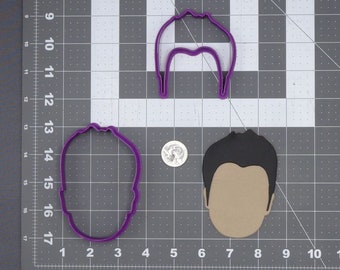 May include: Two purple plastic cookie cutters in the shape of a person's head, one with hair and one without. A brown paper cutout of a person's head with hair is also shown.