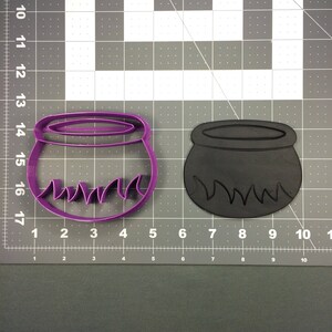 May include: Two plastic cookie cutters shaped like cauldrons with flames around the bottom. One is purple and the other is black.