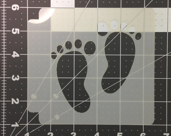 Peut inclure: Un pochoir en plastique blanc avec deux empreintes de pieds noires. Le pochoir est sur un fond de grille noir et blanc.