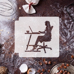 May include: White stencil of a person sitting at a desk with a laptop, a cup, and a chair with wheels. The stencil is on a brown surface with flour scattered around it.