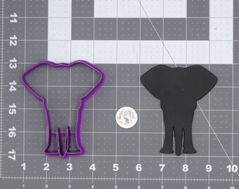 May include: Purple plastic elephant cookie cutter on a gray grid background. A black elephant cookie cutter is to the right of the purple cutter.