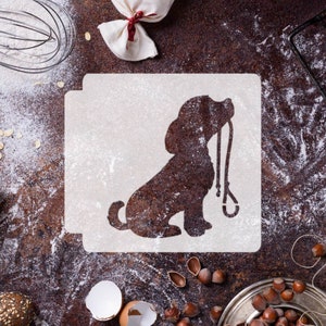 Può includere: Uno stencil bianco di un cane seduto con un guinzaglio in bocca. Lo stencil è su una superficie marrone con farina sparsa intorno.
