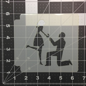 May include: A stencil of a couple getting engaged. The man is kneeling and holding a ring, while the woman is standing with her hand outstretched.