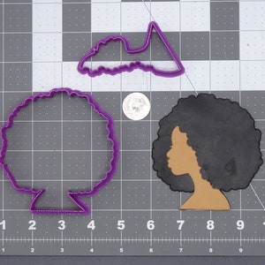 Könnte beinhalten: Drei violette Plastik-Ausstecher: ein Frauenkopf mit Afro, ein Kreis mit welligem Rand und eine einfache Form, die an eine Wolke erinnert.