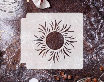 May include: White plastic stencil with a sun design. The stencil is on a brown surface with flour and other baking supplies.