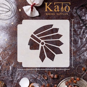 May include: A white stencil with a black silhouette of a Native American headdress. The stencil is 5 inches wide and 5 inches tall. The stencil is on a brown background with flour and other baking supplies.