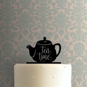 Op de afbeelding: Zwarte silhouet van een theepot met de tekst "Tea Time" op een witte taart.
