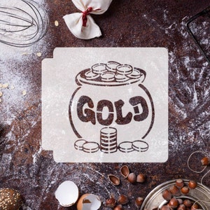 May include: A white stencil with a pot of gold design. The pot is filled with gold coins and has the word "GOLD" written on it. There are also stacks of gold coins below the pot.