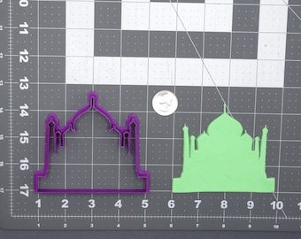 May include: Purple plastic cookie cutter in the shape of the Taj Mahal. A green plastic cookie cutter in the same shape is shown to the right of the purple cutter.
