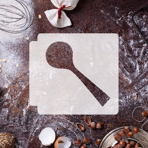 May include: A white stencil of a wooden spoon on a brown surface covered in white flour. The stencil is on a white background.