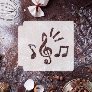 May include: White stencil featuring a treble clef, two musical notes, and a burst of light. The stencil is on a brown surface with flour and other baking supplies.