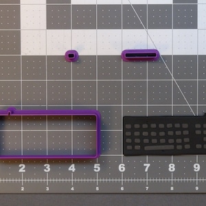 May include: Purple plastic cookie cutters shaped like a computer keyboard, a computer mouse, and a computer monitor.