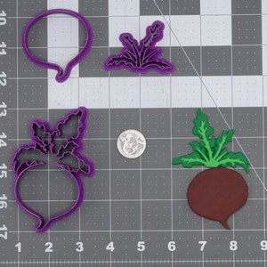 May include: Purple plastic cookie cutters in the shape of a beet, beet leaves, and a circle. A brown beet cookie cutter is also shown.