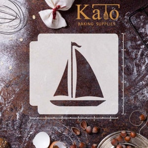 May include: A white plastic stencil of a sailboat with a black outline. The stencil is 5 inches wide and 5 inches tall. The stencil is on a brown surface with a ruler marked in inches.