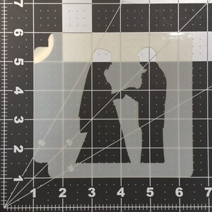 Puede incluir: Una silueta blanca de una pareja tomándose de la mano, la mujer lleva un velo y el hombre lleva un traje. La silueta está sobre un fondo de plástico transparente.