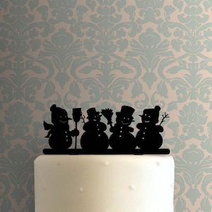 May include: Black silhouette of four snowmen with different accessories, including a broom, a bucket, and a stick. The snowmen are standing on a white cake.